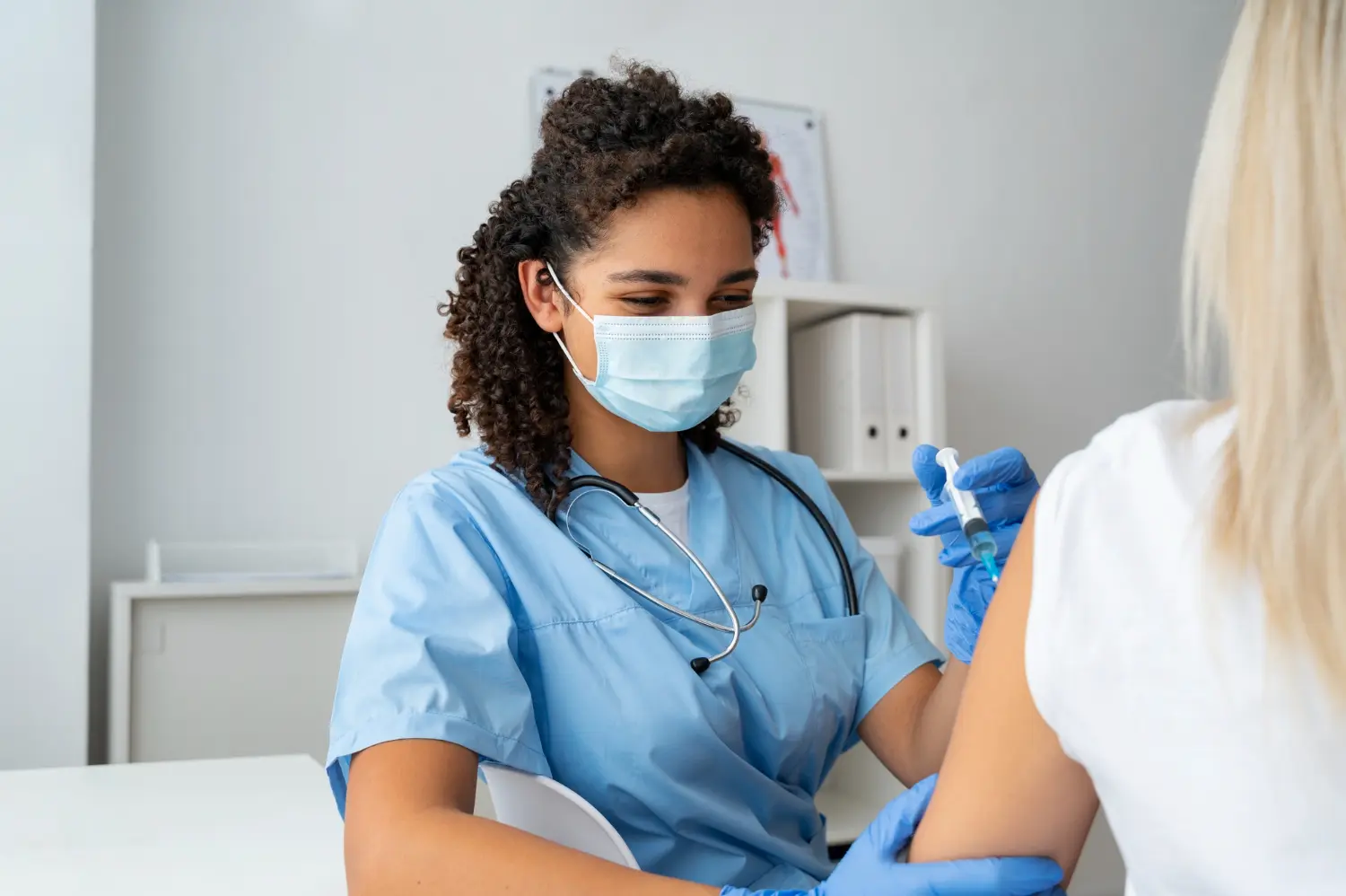 Enfermeira em hospital aplica injeção usando luvas, máscara e práticas de biossegurança na enfermagem