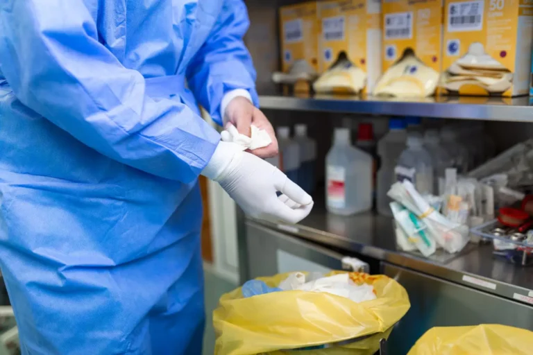 Um profissional de saúde descartando materiais hospitalares.