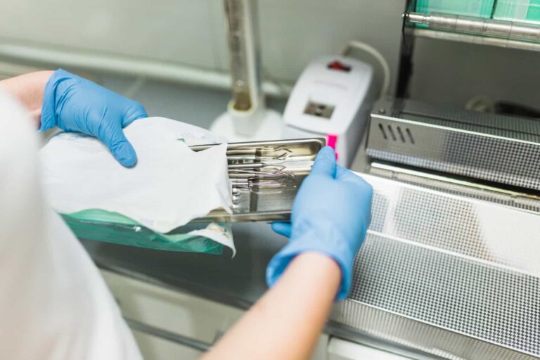 Profissional abrindo embalagem de instrumentos após desinfecção e esterilização para uso em procedimento