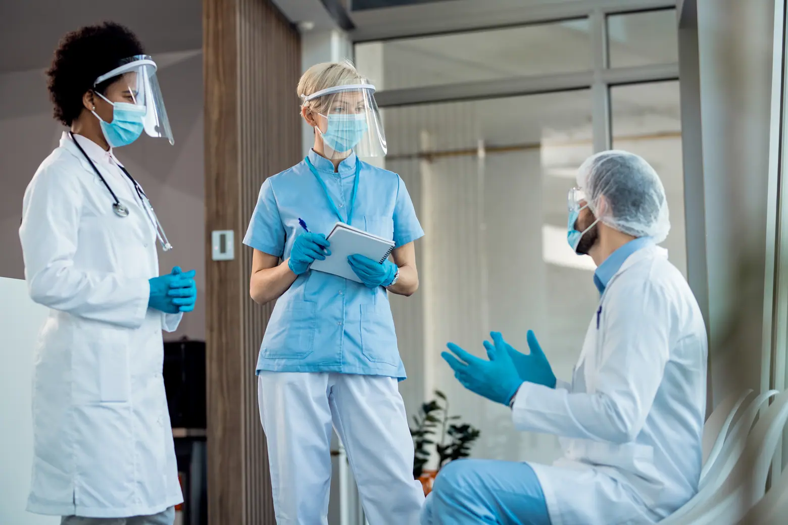 Profissionais de saúde usam EPIs durante reunião sobre segurança e cumprimento da NR 32